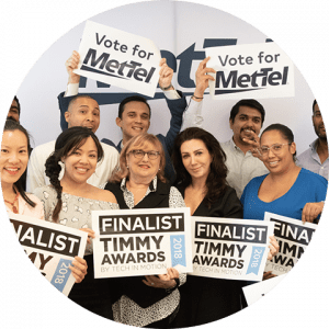 business-telecom-provider-image-Men and women MetTel employees holding Timmy Awards 2018 Finalist and Vote for MetTel signs