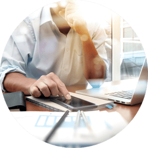 man sits in front of computer with a smartphone