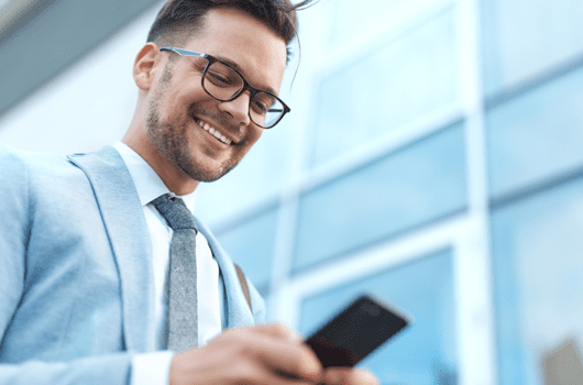 iphone lite coming to market in 2020 - smiling businessman looking down at smartphone
