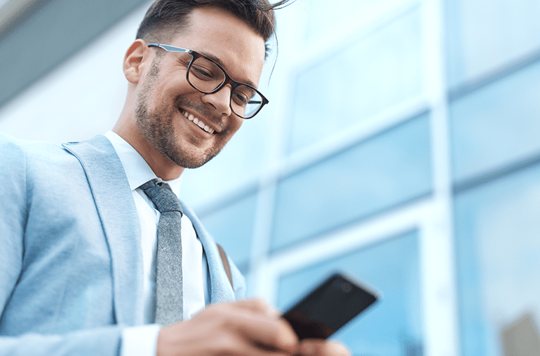Featured blog - iphone lite coming to market in 2020 - smiling businessman looking down at smartphone
