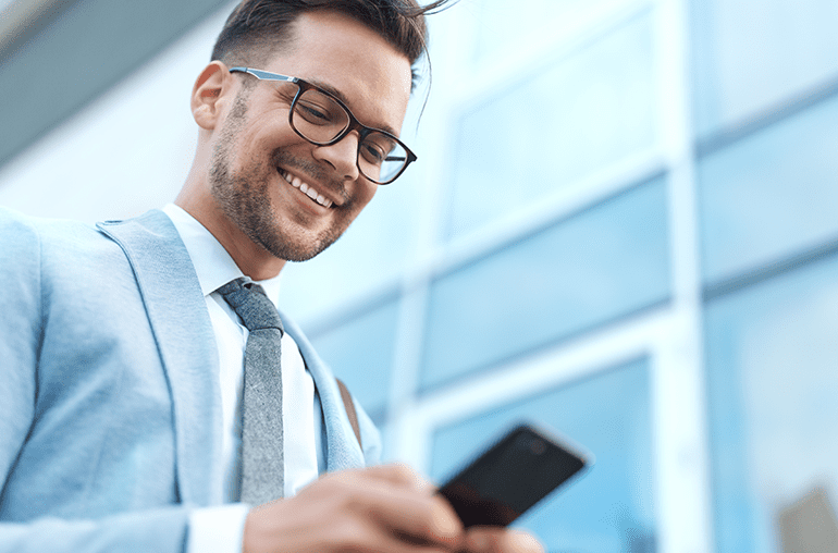 iphone lite coming to market in 2020 - smiling businessman looking down at smartphone