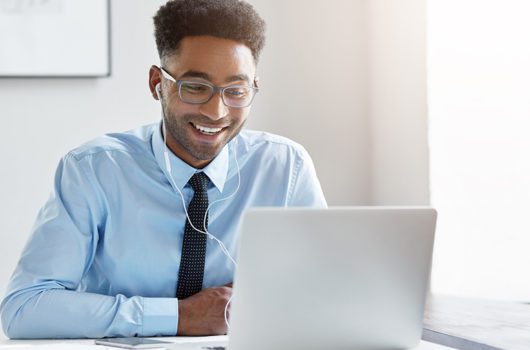 Man working remotely on laptop with headphones