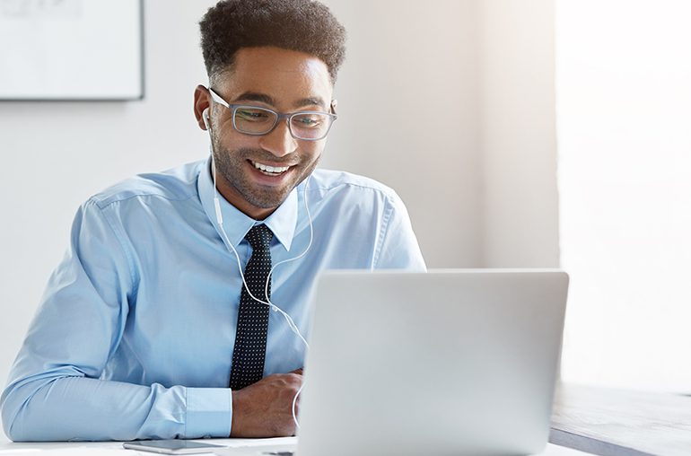 Man working remotely on laptop with headphones