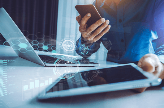 Business person using laptop, smartphone and tablet