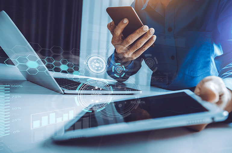 Business person using laptop, smartphone and tablet