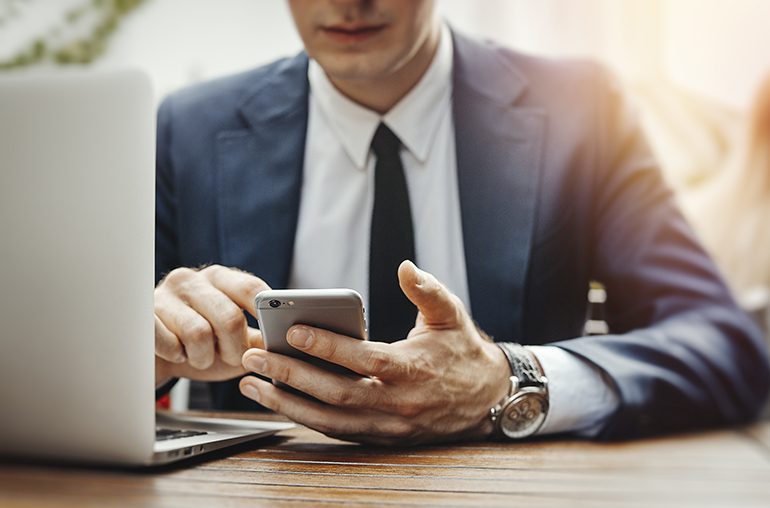 Business man using smartphone and laptop