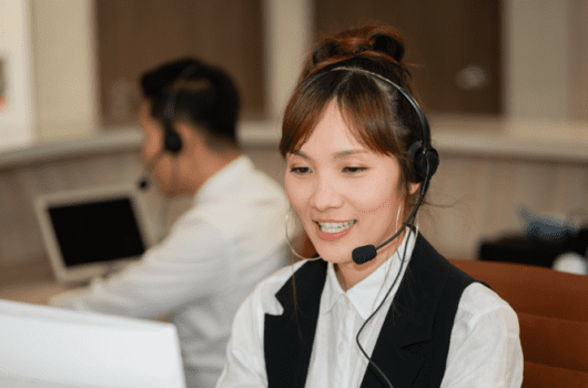 woman with a headset talks into computer