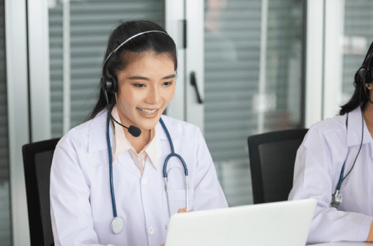 woman with a headset talks in front of computer